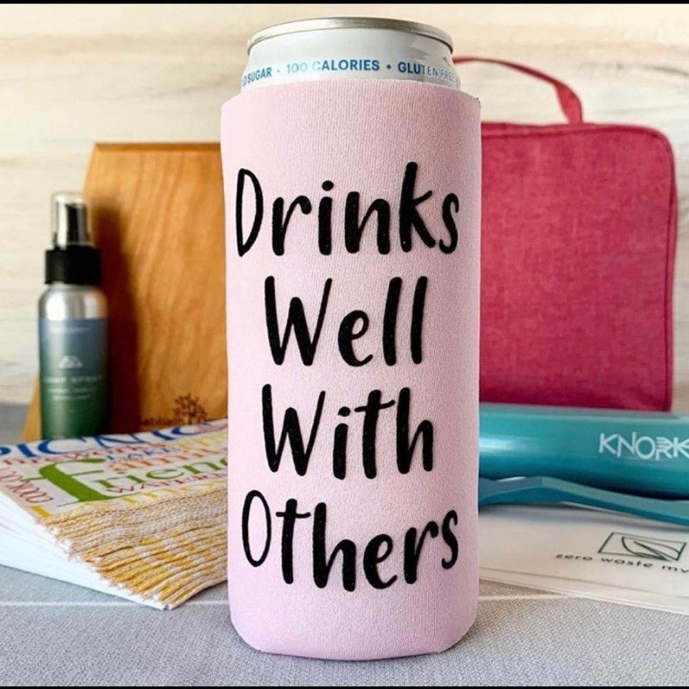 Set of 4 Light pink slim can koozie says, “Drinks well with others.”